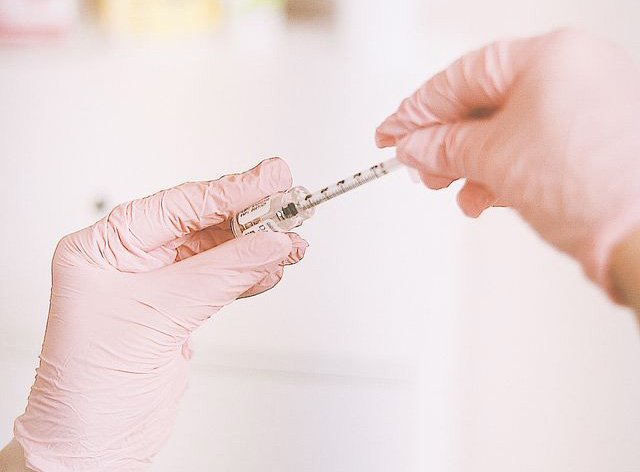 Manos sosteniendo inyección para mesoterapia